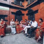 Tourists observing local customs near a Hindu temple in Kathmandu, Nepal